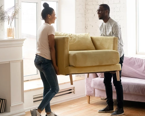 Couple moving sofa | Carpetland USA Granite & Flooring