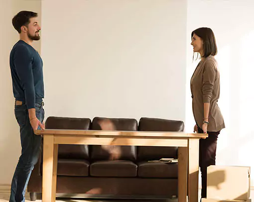 Couple Moving Furniture for floor installation | Carpetland USA Granite & Flooring