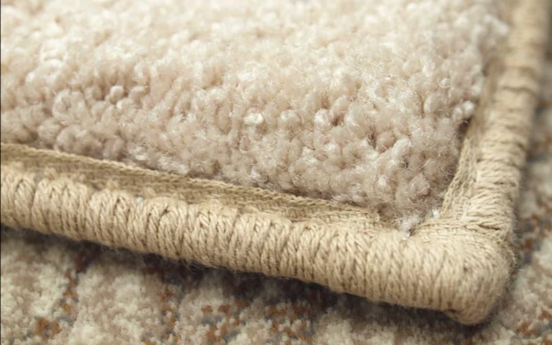 Close-up of professionally bound carpet edges | Carpetland USA Granite & Flooring