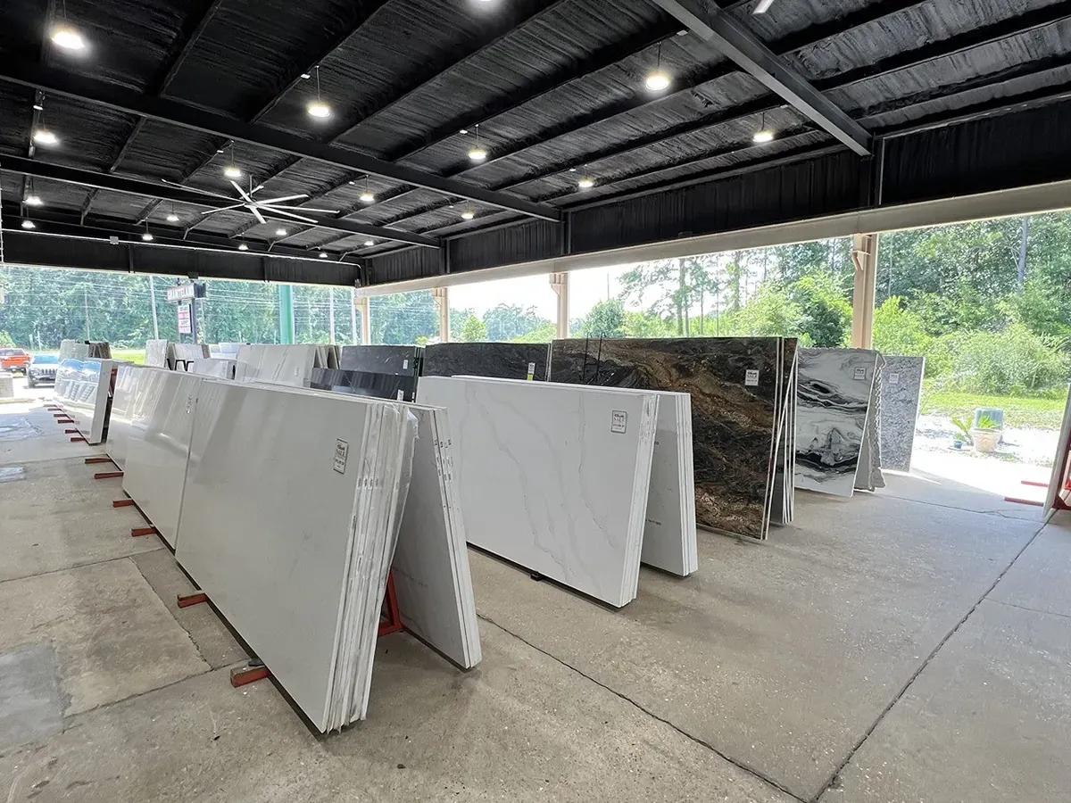 Rows of granite and quartz slabs displayed in an indoor showroom | Carpetland USA Granite & Flooring