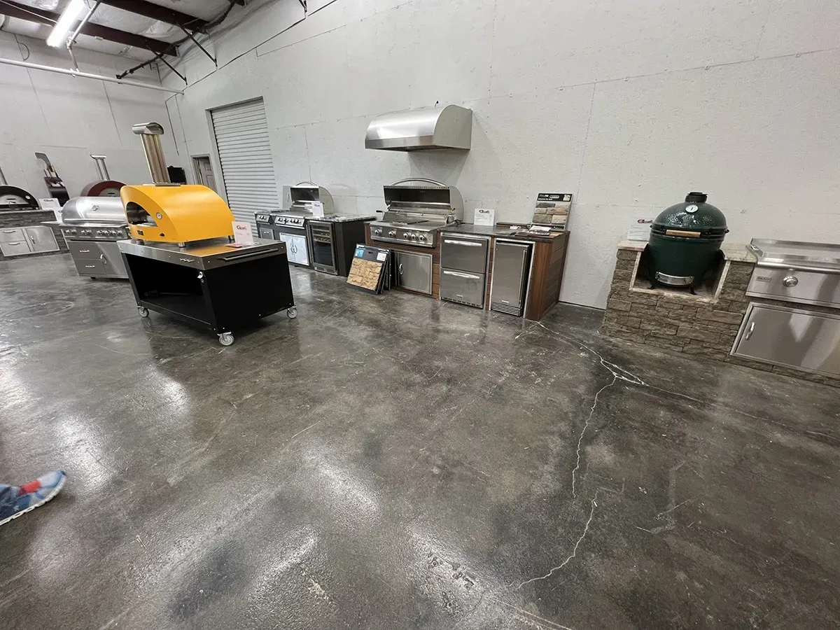 Outdoor grills, pizza ovens, and kitchen appliances on display in a showroom | Carpetland USA Granite & Flooring
