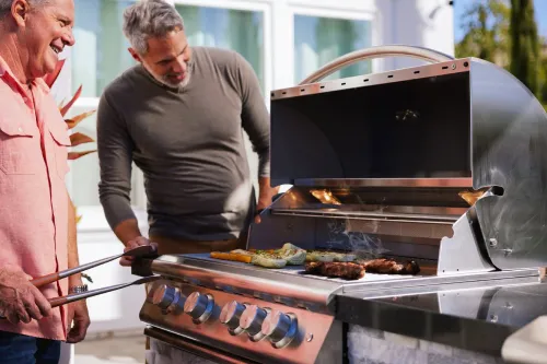 Two men cooking on Outdoor Grill | Carpetland USA Granite & Flooring