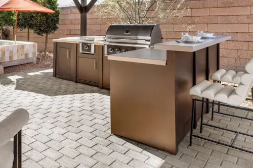 An outdoor kitchen with bar seating and a grille | Carpetland USA Granite & Flooring