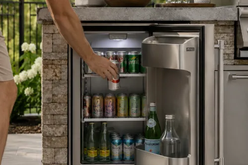 Person getting a soda out of an outdoor refrigerator | Carpetland USA Granite & Flooring
