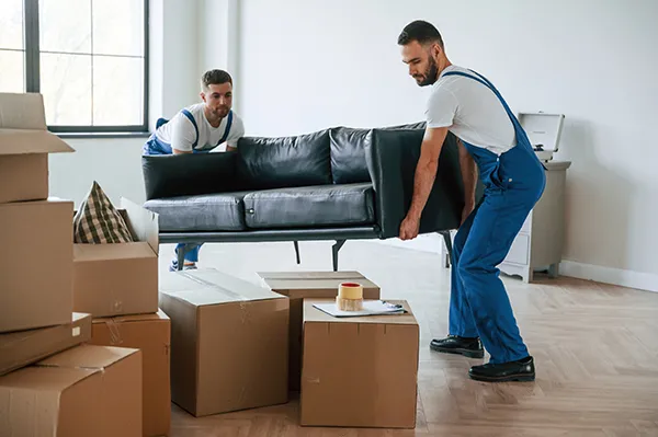 Furniture removal professionals loading household furniture into a moving truck | Carpetland USA Granite & Flooring