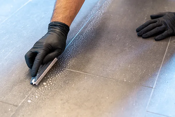 rofessional cleaning grout by hand with a grout brush | Carpetland USA Granite & Flooring